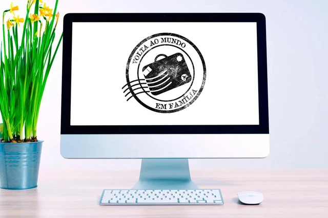 Logo do programa Volta ao Mundo em Família, em estilo de carimbo postal, na tela de um computador